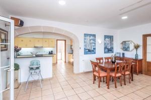 Una cocina y un comedor con mesa y sillas. en Villa Alaris, en Santo Tomás