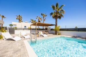 a pool with chairs and a gazebo next to a house at Villa Salty Sun 2 in Kremasti