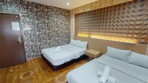 a hotel room with two beds and a wall at Hotel Zamburger Sri Petaling in Kuala Lumpur