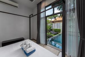 Ένα ή περισσότερα κρεβάτια σε δωμάτιο στο VILLA JAVA| 2 Bedroom Private Pool Villa in Popular Onyx Villas | 3 min to Naiharn Beach
