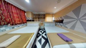 a small room with two beds and a window at Serdang Business Hotel in Kuala Lumpur