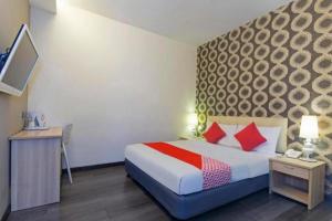 a hotel room with a bed with red pillows at i-Hotel @ Johor Bahru in Kampong Telok Serdang