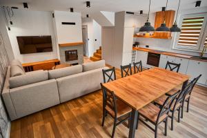 a living room with a couch and a table and chairs at Zdrojowe Zacisze in Iwonicz-Zdrój