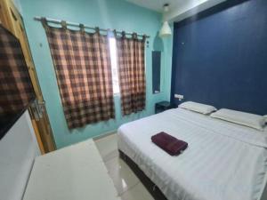 a bedroom with a bed with a purple towel on it at OYO 90862 Hotel Small City in Klang +24 photos
