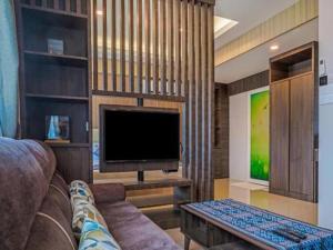 a living room with a couch and a flat screen tv at Rajawali Homes Kota Marudu in Kampong Tumsun