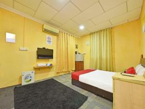 a hotel room with a bed and a tv at OYO 90535 Wakaf Bharu Inn in Kota Bharu