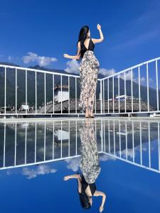 una mujer parada en el borde de una piscina en SIXI CANGSHAN MOUNTAINS GOLDEN SUNRISE MIRROR OF THE SKY SOUND SLEEP HOTEL DALI ANCIENT CITy, en Dali