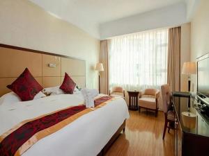 a hotel room with a bed with a stuffed animal on it at Haikou Conifer Garden Hotel in Haikou +249 photos