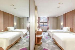 eine Reihe von Betten in einem Hotelzimmer in der Unterkunft Shenzhen Lavande Hotel Airport Terminal Branch in Baoan + 191 Fotos