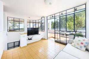 Μια τηλεόραση ή/και κέντρο ψυχαγωγίας στο Spacious 3BR Penthouse w Rooftop 7 min from Beach and Shelter by Sea N' Rent