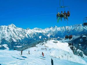 eine Gruppe von Menschen, die einen Skilift auf einem schneebedeckten Berg reiten in der Unterkunft Apartment in Saalfelden near Ski Slopes in Saalfelden am Steinernen Meer + 28 Fotos