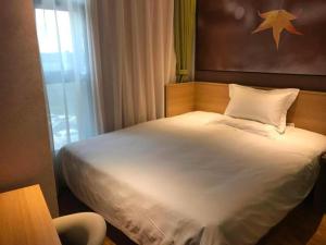 a bedroom with a white bed with a star on the wall at IU Hotel Taizhou Wanda Plaza in Taizhou