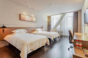a hotel room with two beds and a desk at Jinjiang Inn Select Xinji Xinghua Road in Xinji +232 photos