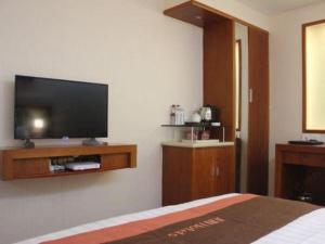 a bedroom with a flat screen tv on the wall at Jun Hotel Guizhou Guiyang Yunyan District Yunyan Square in Guiyang