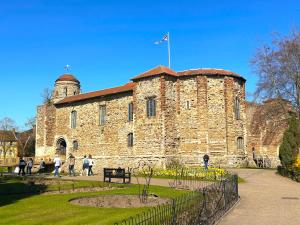 un gran edificio de ladrillo con una bandera encima en Colchester City Luxury With Free Parking and 5 G WIFI, en Colchester