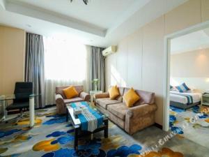a living room with a couch and a bed at Kunshan Yuxing Hotel in Kunshan