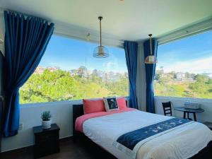 une chambre avec un lit et une grande fenêtre dans l'établissement May Trang Villa, à Xuan An