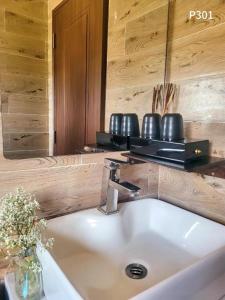 ein Waschbecken mit einer Vase aus Blumen und einem Spiegel in der Unterkunft May Trang Villa in Xuan An