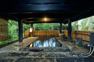 a pool of water under a pavilion at Shinwaen in Aso