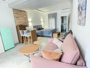 a living room with a pink couch and a table at Carezza Apartments in Preveza