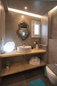 a bathroom with a sink and a mirror and a toilet at Carezza Apartments in Preveza