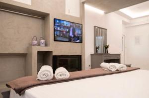 a bedroom with a bed with towels and a tv at Carezza Apartments in Preveza