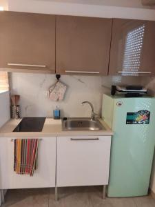 a small kitchen with a sink and a refrigerator at Carezza Apartments in Preveza +58 photos
