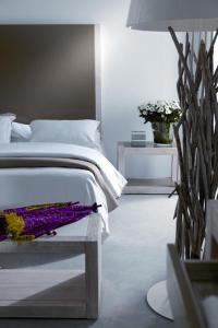 1 dormitorio con 1 cama y 1 mesa con flores en Hospedium Hotel Convento de Santa Ana en Atienza