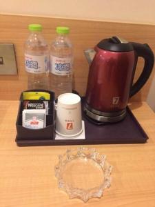 a tray with a coffee maker and bottles of water at 7 Days Premium Chongqing Fuling Binjiang Avenue Branch in Fuling