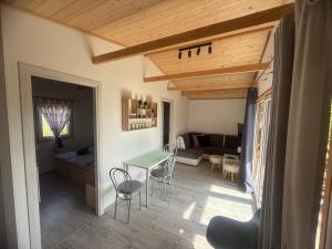 a kitchen and living room with a table and chairs at Domki Letniskowe Kosewo in Kosewo