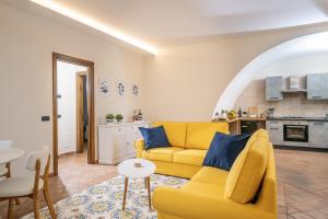 a living room with a yellow couch and a kitchen at Luna Guest House - Italian Escape in Vico Equense