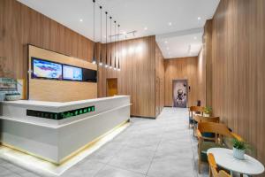 un hall avec un comptoir, des tables et des chaises dans l'établissement Vatica Yangzhou Dongguan Street Hotel, à Yangzhou