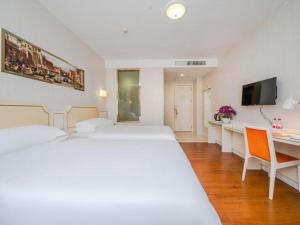 a hotel room with two beds and a desk at Vienna 3 Best Hotel Shenzhen Shazui Road Branch in Shenzhen