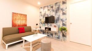a living room with a couch and a tv at Greenbelt Makati - Vaccinated Staff in Manila