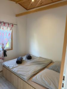 a bed in a bedroom with two bags on it at Domki Letniskowe Kosewo in Kosewo