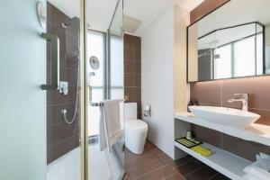 a bathroom with a sink and a toilet and a mirror at IU Hotel Shanwei Haifeng Passenger Station in Shanwei