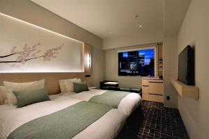 a hotel room with two beds and a flat screen tv at Hotel Yaenomidori Tokyo in Tokyo