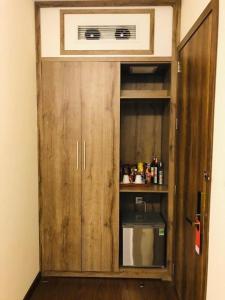a wooden cabinet with a microwave in a room at Huyen Nga Hotel in Buôn Kô Sir