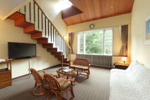 a living room with a staircase and a tv at Fuji Shoei kaikan in Fuji