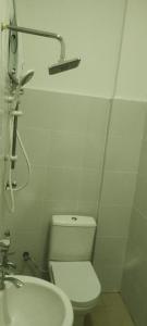 ein weißes Badezimmer mit Toilette und Waschbecken in der Unterkunft OYO 90471 Hotel Tepoh in Kampong Banggol Binjai