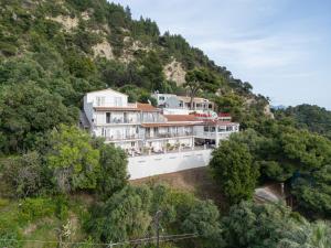 a large white building on a hill with trees at Bella Vista Apartments in Pelekas
