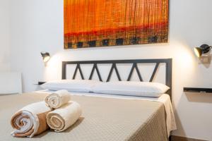 a bed with two rolled towels on top of it at Villa Campidanese in Assemini