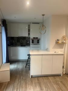 a kitchen with white cabinets and a kitchen island at Beautiful Cocoon in Neuchâtel