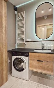 ein Badezimmer mit Waschmaschine und Waschbecken in der Unterkunft HolidayHomePL Sea & Forest D344 z sypialnią, basen, spa, gym GRATIS in Misdroy