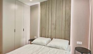 ein Schlafzimmer mit einem Bett und zwei Tischen in der Unterkunft HolidayHomePL Sea & Forest D344 z sypialnią, basen, spa, gym GRATIS in Misdroy + 20 Fotos