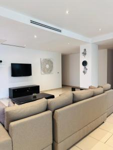 a living room with a couch and a flat screen tv at Villaggio Vista Furnished 3 bedroom room 1st Floor flat & Service room in Accra