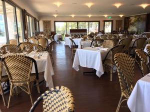 uma sala de jantar com mesas e cadeiras com toalha de mesa branca em Riversdale Estate Cottages em Cambridge