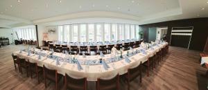 a large meeting room with a long table with chairs at Hotel Krone in Königsbrunn