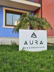 een bord in het gras voor een gebouw bij Aura B&B in Pachino