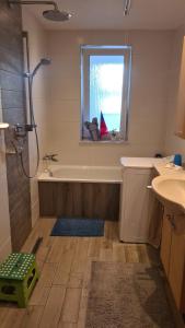 a bathroom with a tub and a sink and a window at Pension Kaden in Dresden